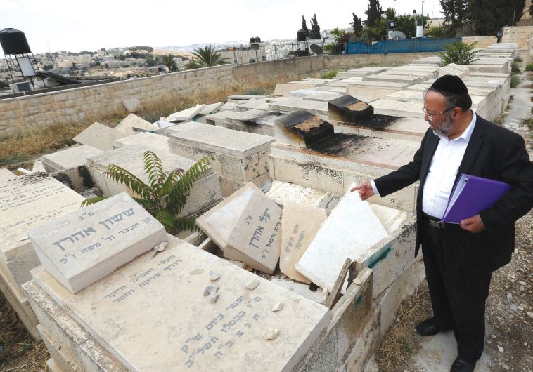 The caretaker of the Afghan section of the Mount of Olives Cemetery points out the vandalism.