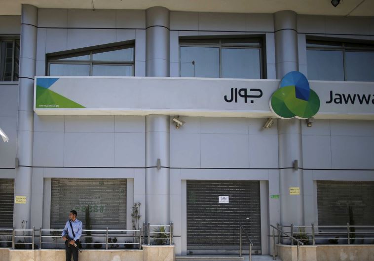Palestinian policemen loyal to Hamas stand guard outside the closed Jawwal company headquarters in Gaza City June 30, 2015. 