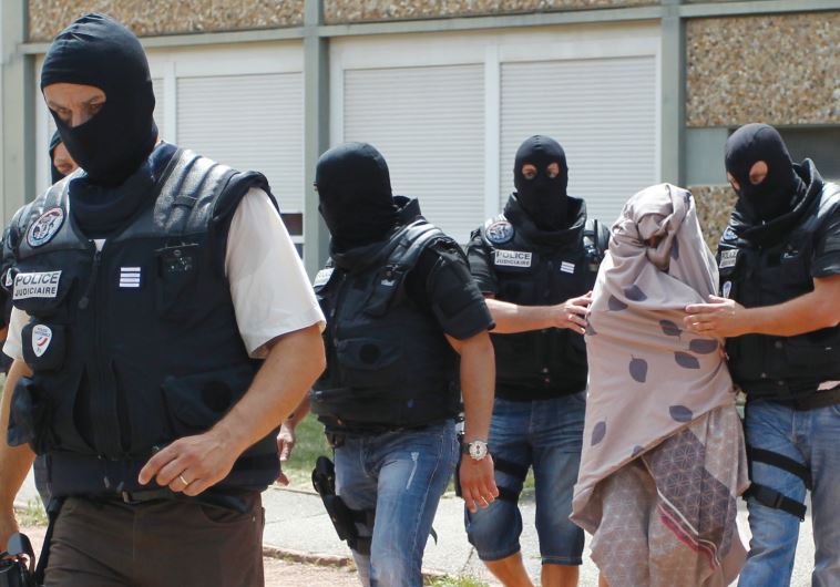 POLICE FORCES escort a woman from a residential building during a raid in Saint-Priest, near Lyon, France, last week in the wake of the terrorist attack where a factory employer was decapitated.