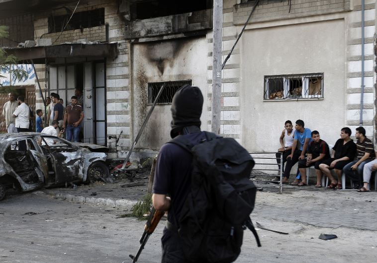 Palestinians gather around a burnt-out car in Gaza City on July 19, 2015, after explosions destroyed five cars in Gaza belonging to members of Hamas and Islamic Jihad, witnesses and a security source said, amid tensions between the Palestinian territory's rulers and Islamist extremists.