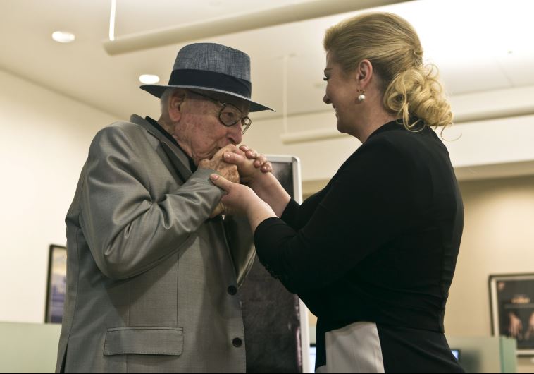 Croatian Auschwitz survivor Branko Lustig (L) kisses the hand of Croatian President Kolinda Grabar-Kitarovic at Yad Vashem Holocaust memorial in Jerusalem