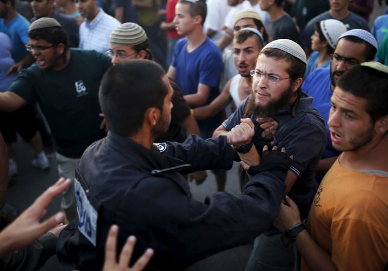 Jewish settlers (R) scuffle with Israeli police officers near buildings slated for demolition by order of Israel's high court in Beit El