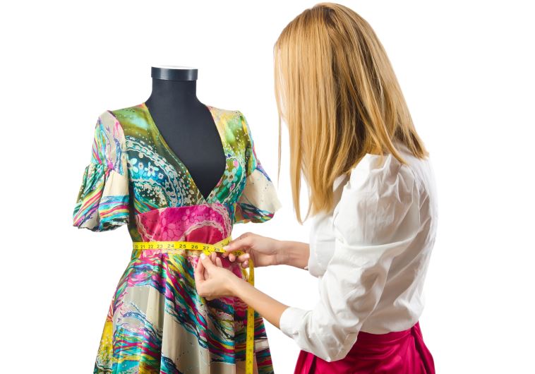 Woman tailor working on dress (illustrative).