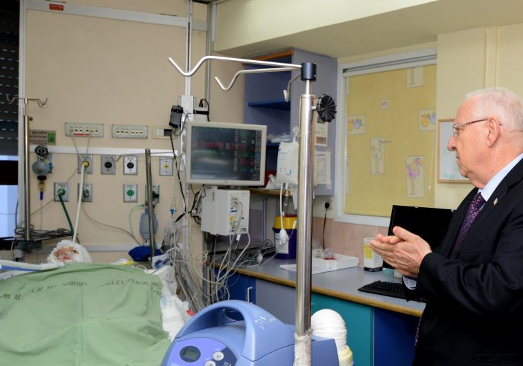 President Reuven Rivlin at the bedside of Ahmed Dawabsha, 4, at Sheba Medical Center in Tel Hashomer