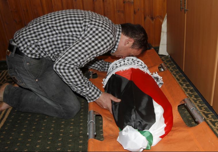 A relative of 18-month-old Palestinian baby Ali Dawabsheh, who was killed after his family's house was set on fire in a suspected attack by Jewish extremists, mourns over his body during his funeral in Duma