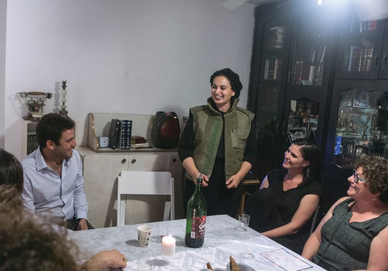 Marlyn Vinig (standing) is ‘At Home’ at the head of her table, flanked by Deputy Mayor Ofer Berkovitch (left).