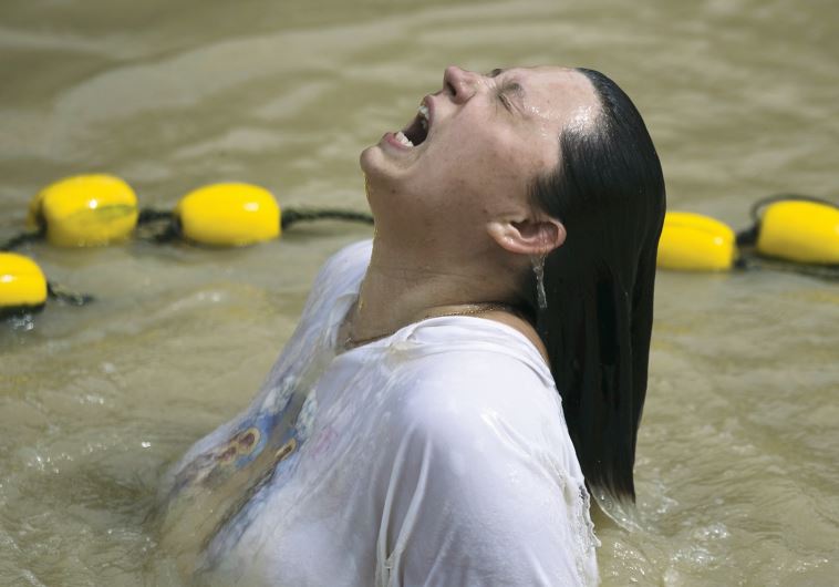 A Christian pilgrim dips in the water during her visit to the Qasr el-Yahud baptismal site on the banks of the Jordan River.