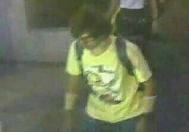 A man wearing a yellow T-shirt and carrying a backpack is seen walking near the Erawan shrine, where a bomb blast killed 22 people in Bangkok, Thailand.