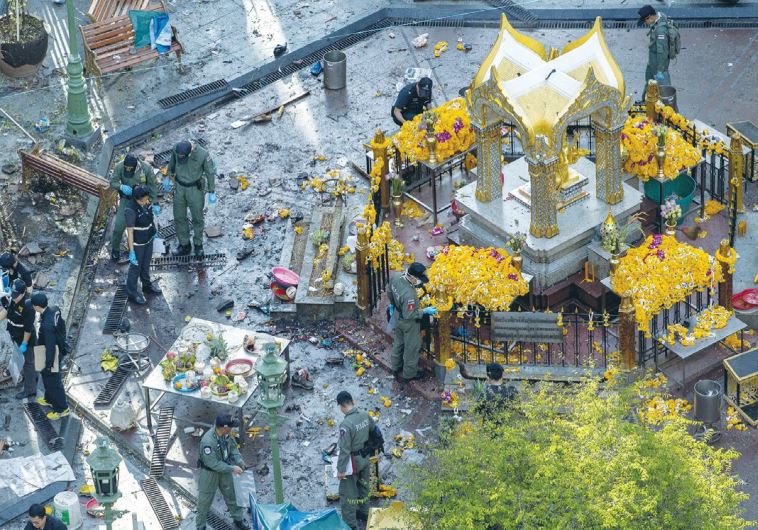 EXPERTS EXAMINE the scene of the explosion at the Erawan Shrine in Bangkok yesterday.
