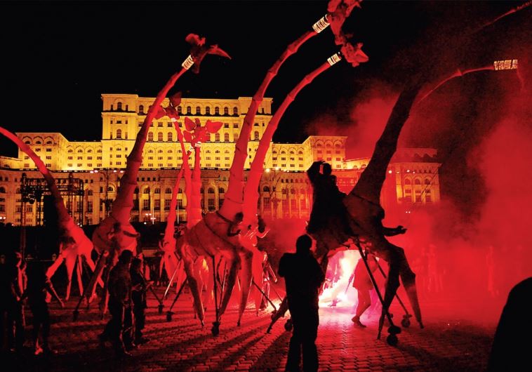 ‘Les Girafes’ by the Compagnie Off street arts gang incorporates red, eight-meter versions of the towering beast, augmented by the vocals of an opera singer.