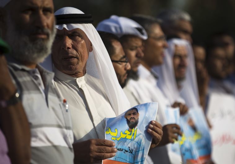 Beduin demonstrators hold signs during a protest in the southern town of Rahat in support of Islamic Jihad activist Mohammed Allan