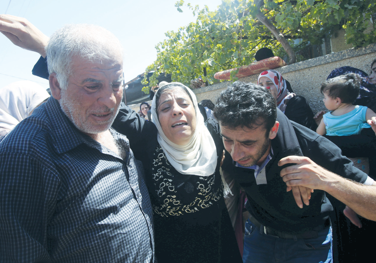 RELATIVES of Sa’ad Dawabsha mourn at his funeral in Duma on August 8.
