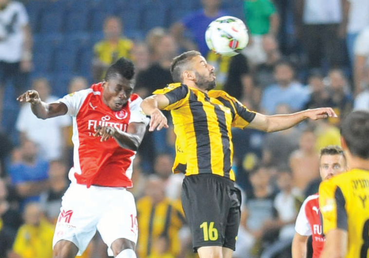 Beitar Jerusalem striker Dovev Gabay (16) and Hapoel Tel Aviv midfielder Issou Lingane (left) challenge for the ball during last night’s 0-0 draw at Teddy Stadium in both clubs’ opening match of the season.