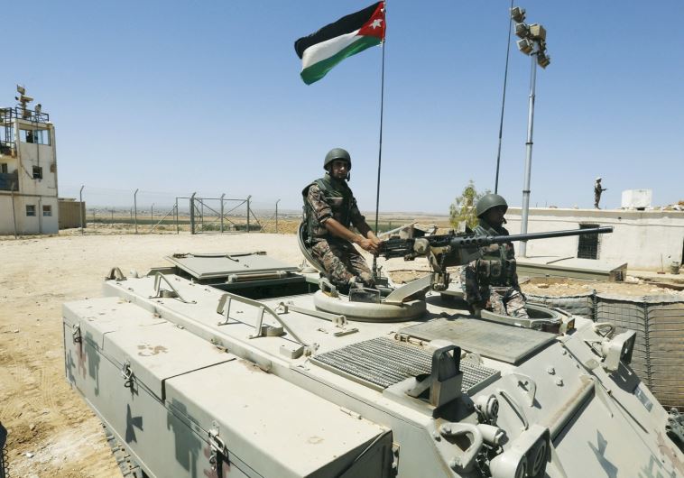 Soldiers stand on a tank at the Jordanian-Syrian border.