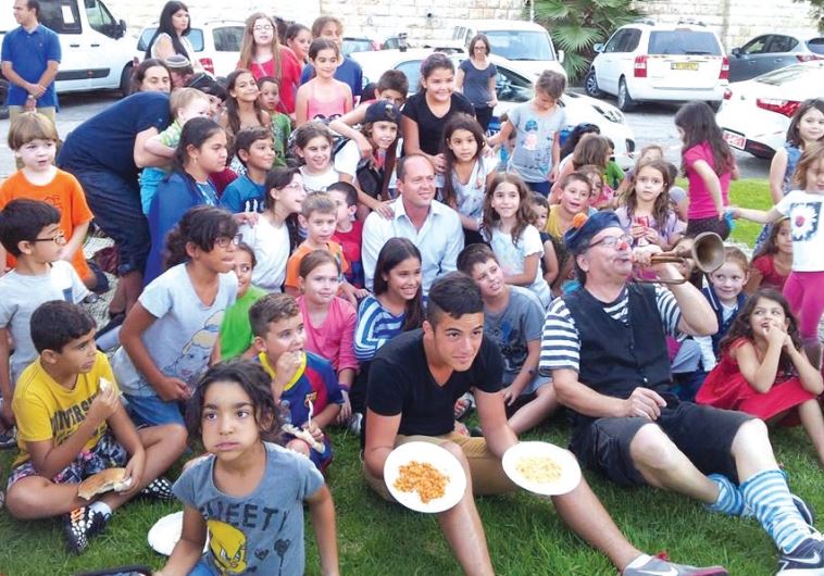Mayor Nir Barkat flanked by hummus lovers of all ages, on Hummus Day 2014