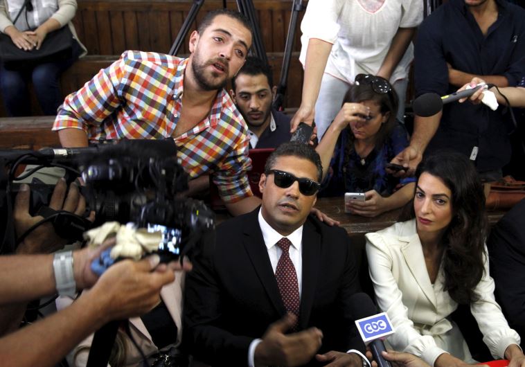 Al Jazeera television journalists Mohamed Fahmy, and Baher Mohamed, talk to the media with lawyer Amal Clooney before hearing the verdict at a court in Cairo.