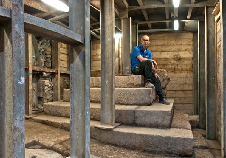 Dr. Joe Uziel, co-director of the excavation from the Israel Antiquities Authority, sits atop the stepped structure from the Second Temple period.