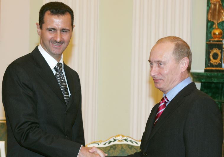 Russia's President Vladimir Putin (R) and Syrian President Bashar Assad shake hands as they meet in the Kremlin