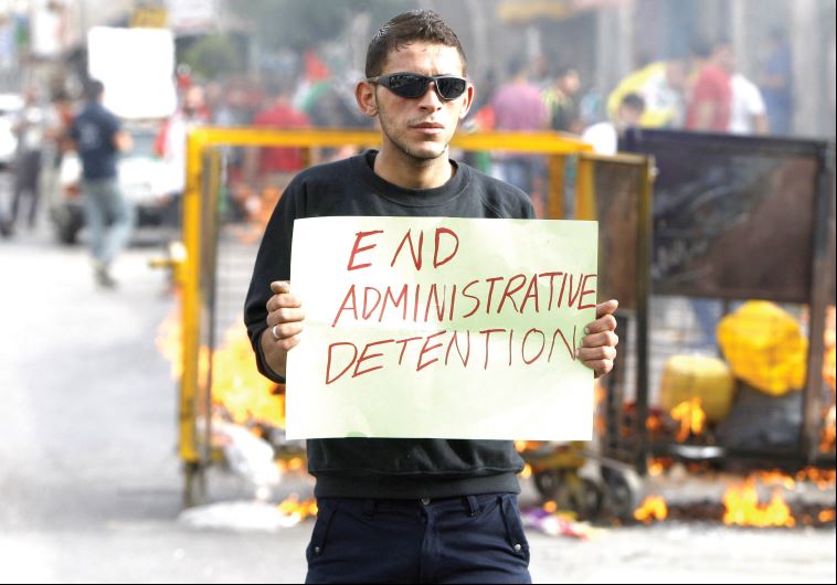 A Hebron man demonstrates in solidarity with Palestinian prisoners on a hunger strike in protest at being held in administrative detention