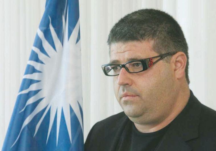 Ran Rahav stands with the flag of the Marshall Islands, of which he is honorary consul