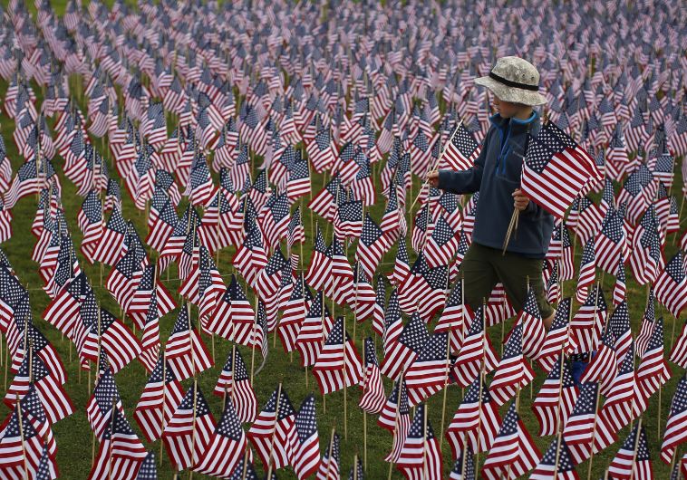 Boy among some of the 3,000 flags placed in memory of lives lost in the September 11, 2001 attacks, at park in Winnetka, Illinois, September 10, 2015.