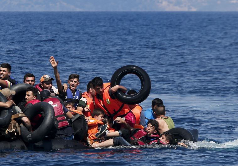 Syrian and Afghan refugees struggle to stay afloat after their dinghy collapses just off the coast of Greece