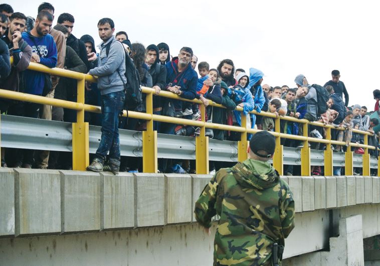 A thousand migrants crowd a bridge crossing from Greece into Macedonia. They are leaving refugee camps in the hope of a new life