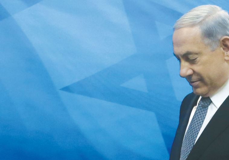 Netanyahu walks to the weekly cabinet meeting at his office in Jerusalem