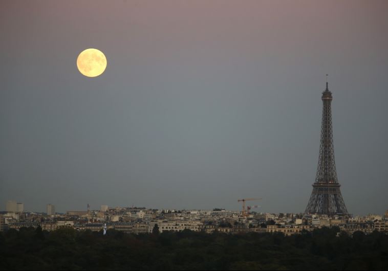 A super moon rises in the sky near the Eiffel tower as seen from Suresnes, Western Paris