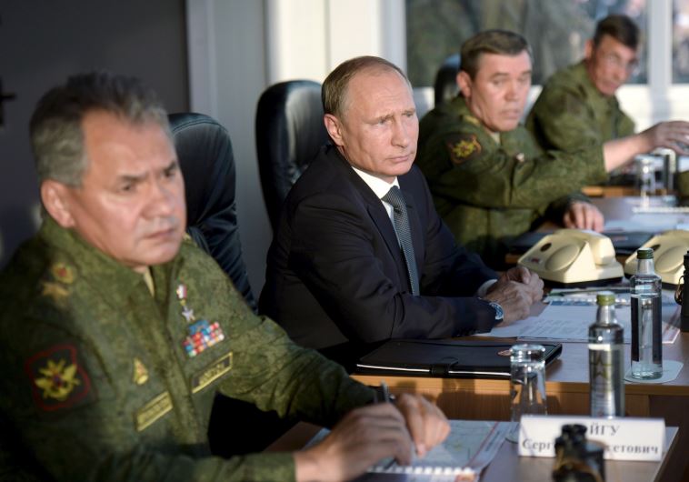 Russian President Vladimir Putin (C) with Defence Minister Sergei Shoigu (L) and armed forces Chief of Staff Valery Gerasimov observe troops during a training exercise 