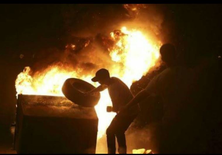 Pro-Palestinian demonstrators light garbage bin on fire during protests in Jaffa, October 6, 2015