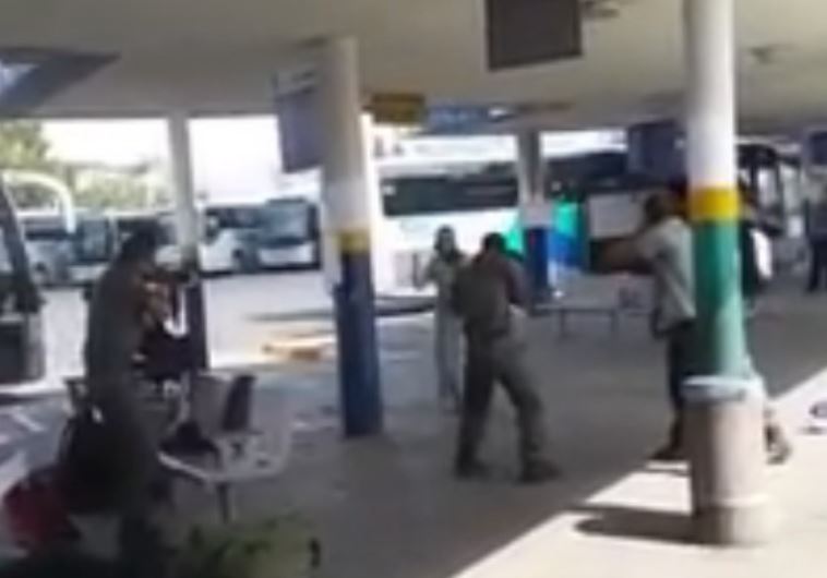 Police aim their weapons at a Palestinian woman armed with a knife at the Afula bus station