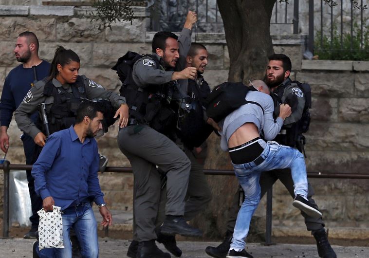 Border Police officers scuffle with a Palestinian protester as they detain him near Damascus Gate outside Jerusalem's Old City