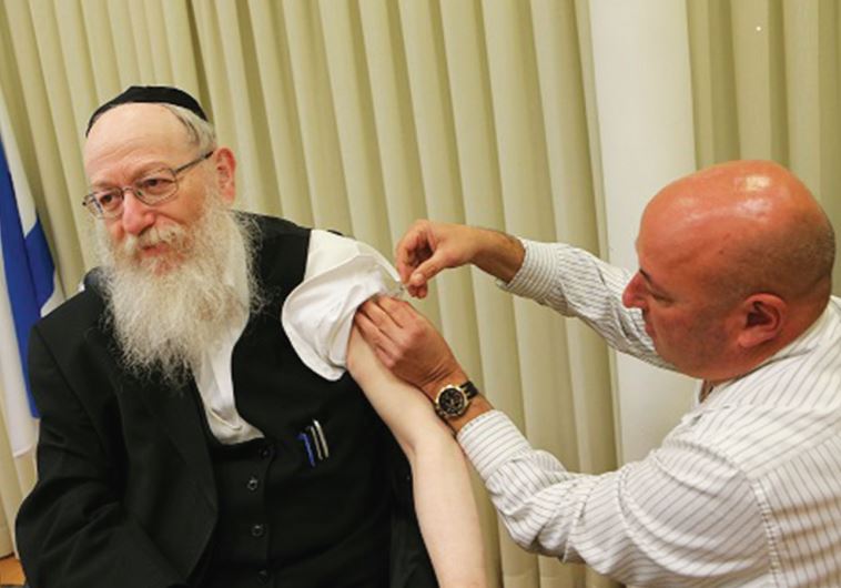 HEALTH MINISTER Yaacov Litzman receives his flu shot from Prof. Itamar Grotto