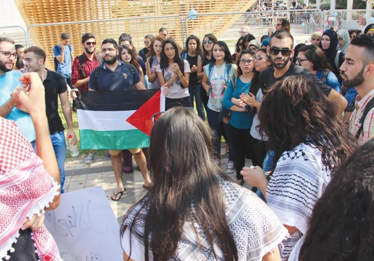 PRO-ARAB PROTESTERS display a Palestinian flag at the entrance to Tel Aviv University yesterday.