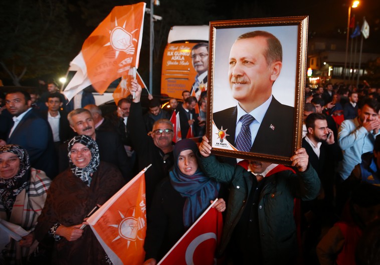 Supporters wave flags and hold a portrait of Turkish President Tayyip Erdogan outside the AK Party headquarters in Istanbul, Turkey November 1, 2015