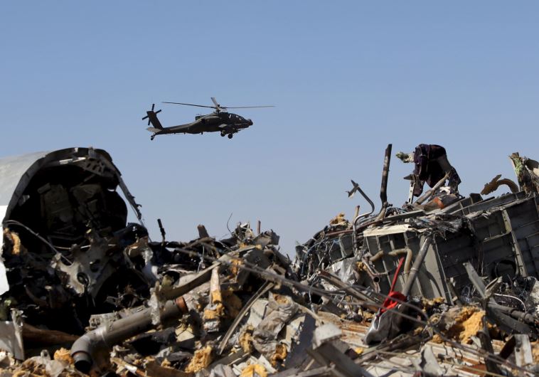 An Egyptian military helicopter flies over debris from a Russian airliner which crashed at the Hassana area in Arish city, north Egypt, November 1, 2015