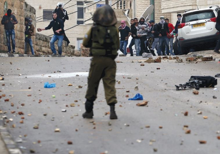 Palestinians hurl rocks at IDF soldiers during clashes in Ramallah