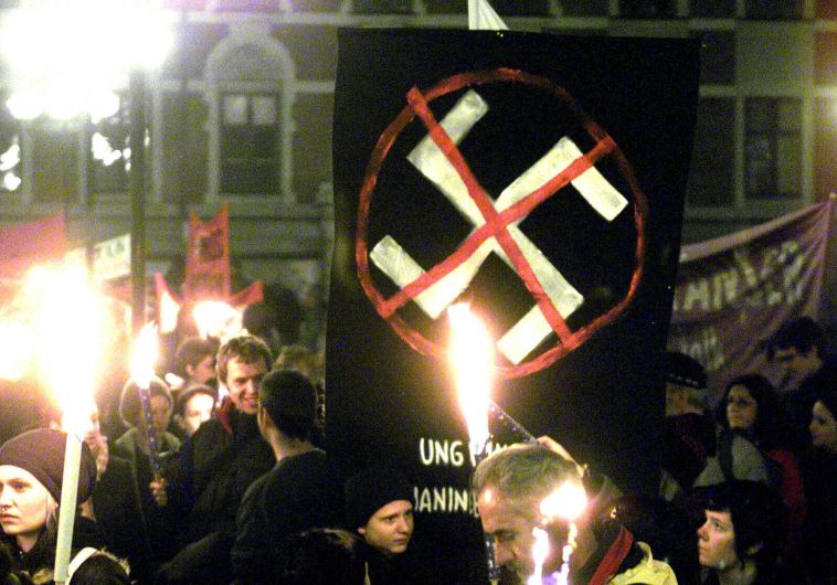 Some thousand people hold banners and torches as they gather in the Maria Square in Stockholm on November 9, 2000, to protest against racism on the anniversary of the Kristallnacht