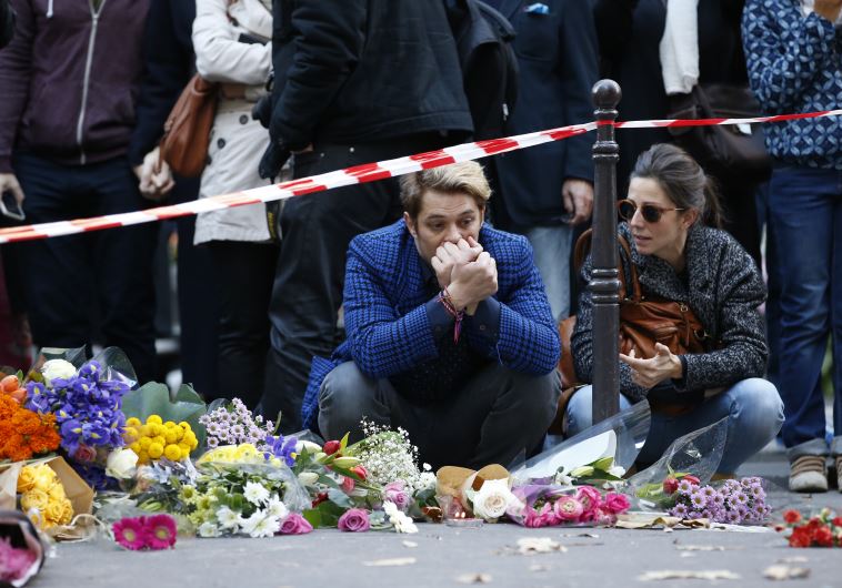 Mourners gather at memorial sites outside of the Casa Nostra restaurant and the cafe "Bonne biere" in Paris, on November 15, 2015, following a series of coordinated attacks in and around Paris on November 13