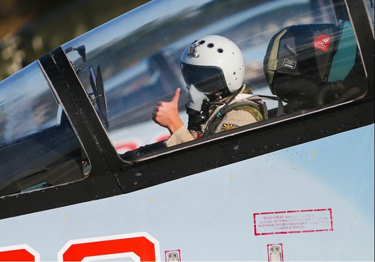 A Russian pilot gives the thumbs-up sign on an airbase in Syria
