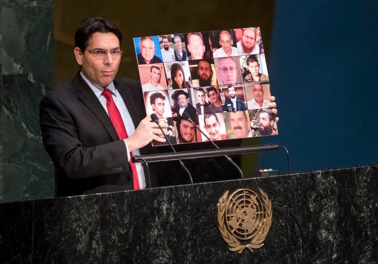 Israel's ambassador to the UN, Danny Danon, holds up a collage of Israeli victims of Palestinian terrorism