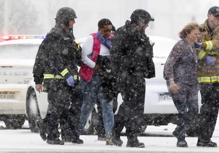 Two women are evacuated from a building where a shooter was suspected to be still holed up in Colorado Springs, Colorado November 27, 2015 in a driving snow storm. 