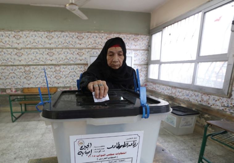 A woman casts her vote at a polling station during the runoff to the first round of parliamentary elections in Imbaba, Egypt, October 27