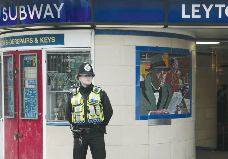 A police officer patrols outside Leytonstone Underground station in east London