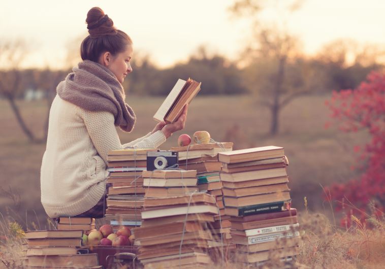 A woman reading a book in a field