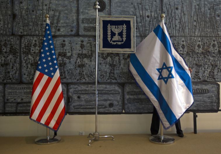 An employee arranges an Israeli national flag next to a U.S. one