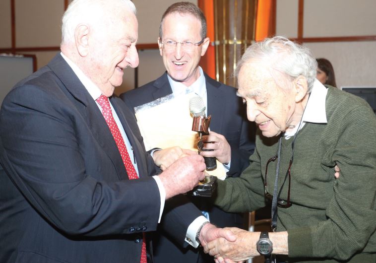 Dr. Zvi Harry Tabor (right), founding father of Israel’s solar energy industry shown receiving an Energy Man of the Year award last month. Handing Tabor the title is businessman Yeshayahu Landau (left), as EcoEnergy CEO Amit Mor looks on
