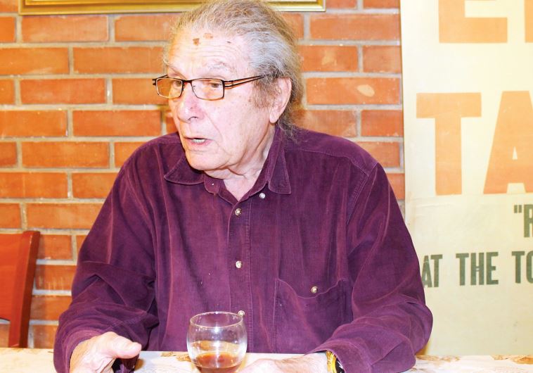 Alexander Tamir enjoys a glass of homemade plum liquor.