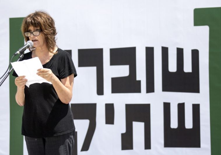 A woman reads testimonies during a gathering in Tel Aviv to commemorate the 10th anniversary of the Israeli NGO "Breaking the Silence"